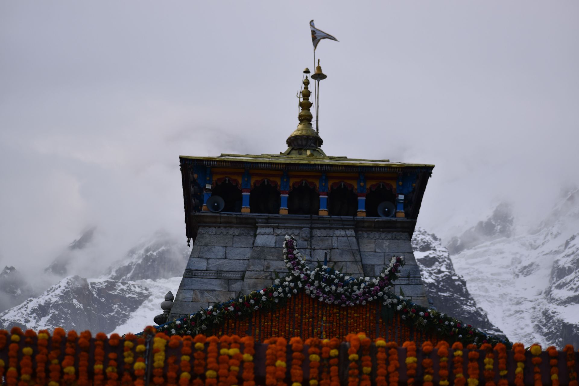 Kedarnath temple dressed in marigolds against snow peaks